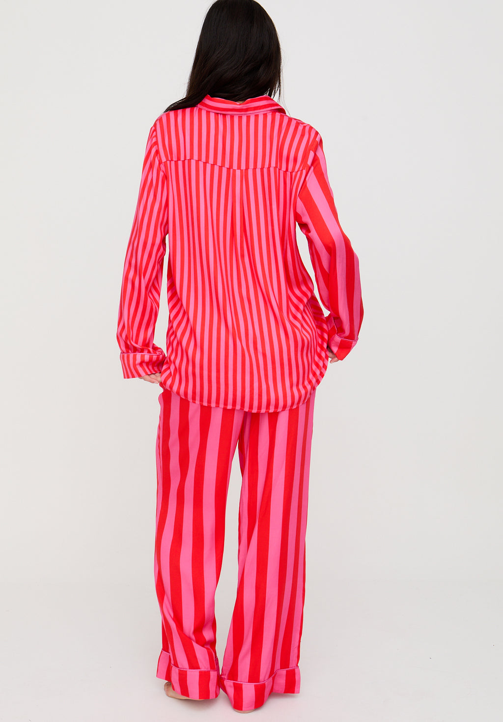 Person wearing red and white striped pajama set on a light gray background