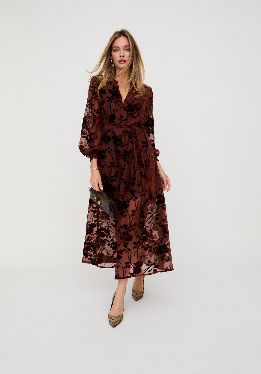 Woman wearing a brown floral dress on a white background
