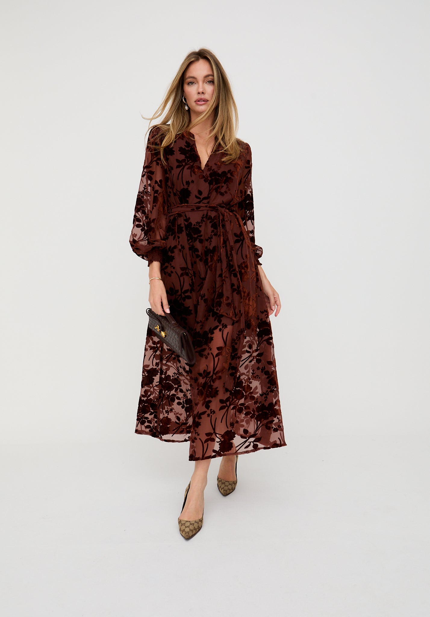 Woman wearing a brown floral dress on a white background