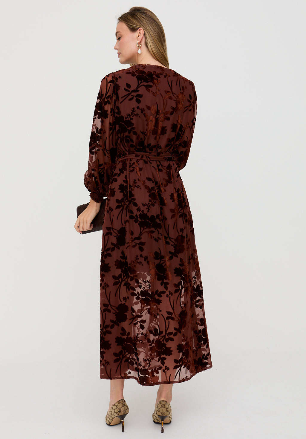 Woman wearing a brown floral dress on a white background