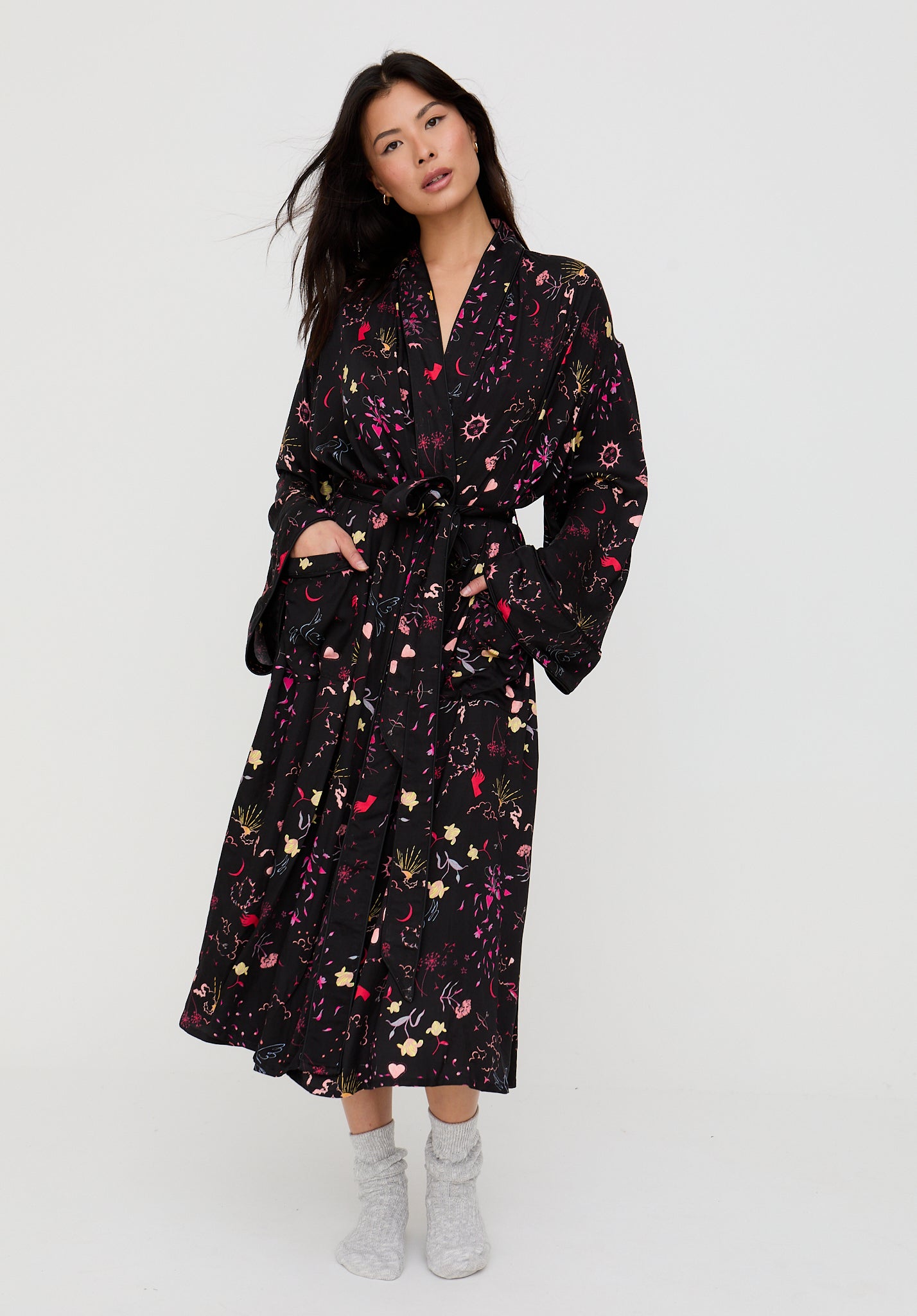 Woman wearing a black floral dress against a white background