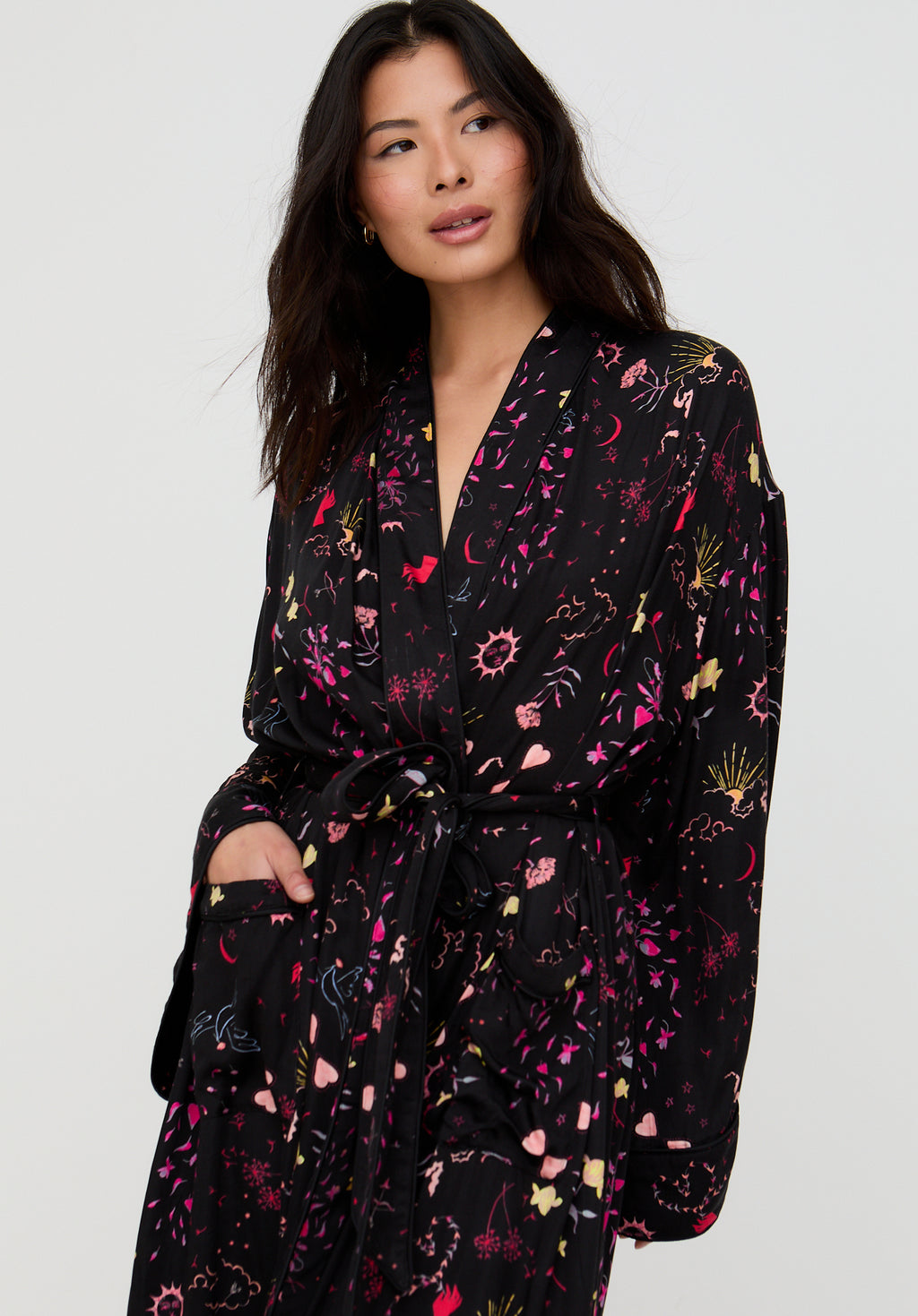 Woman wearing a black floral patterned robe against a white background