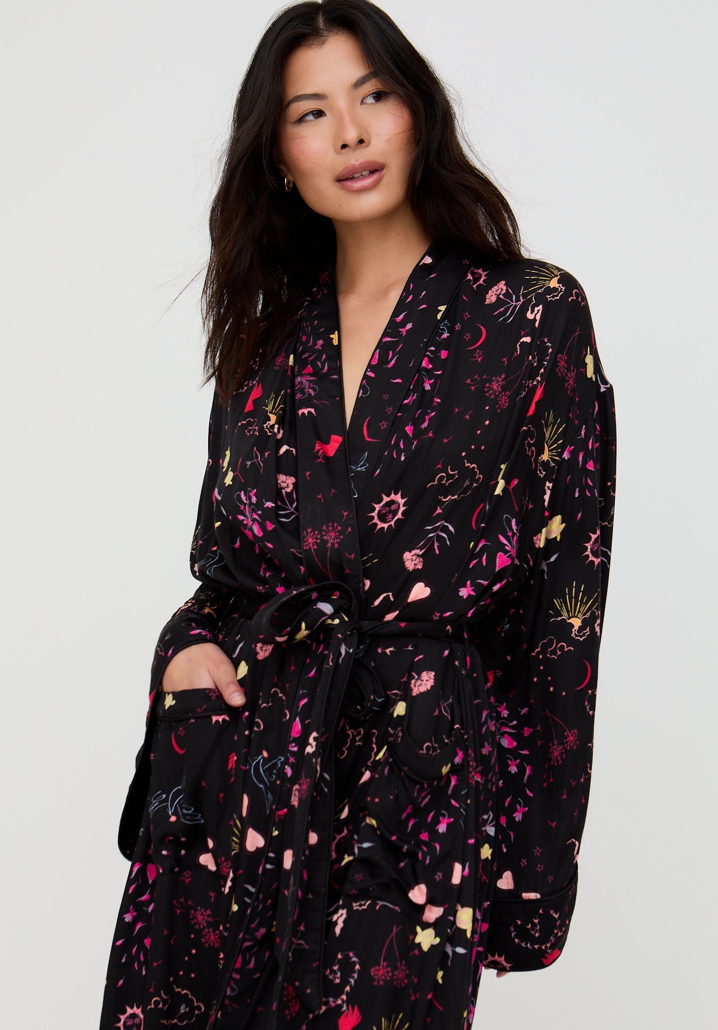 Woman wearing a black floral patterned robe against a white background