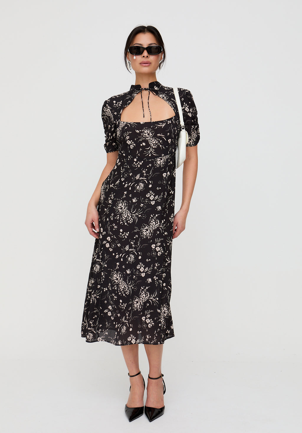 Woman wearing a black floral dress on a white background