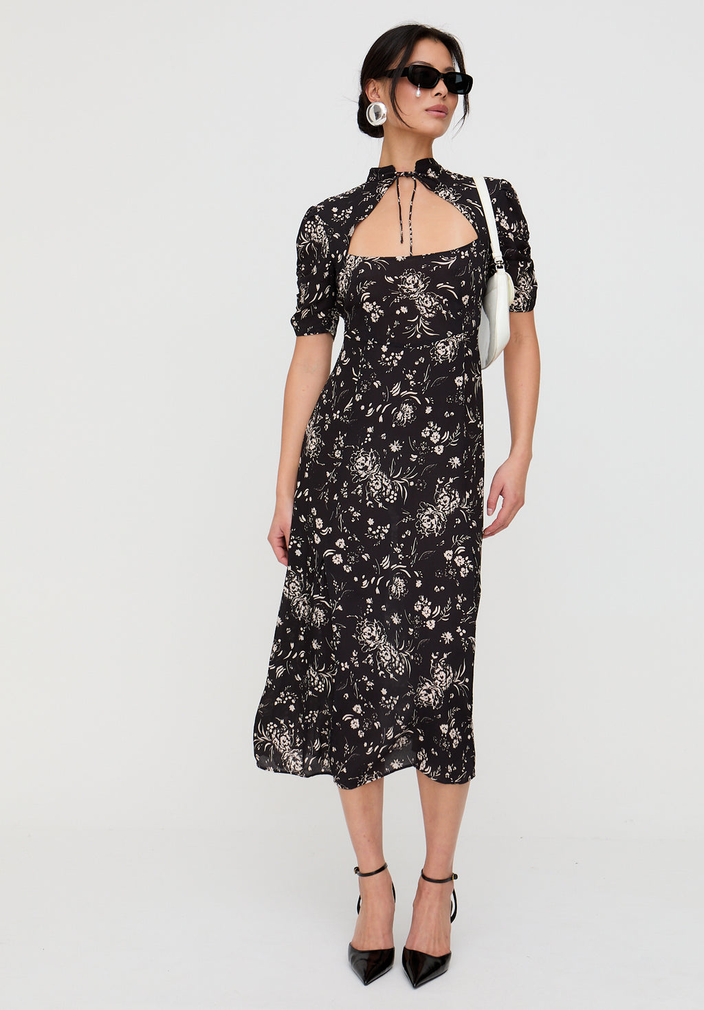 Woman wearing a black floral dress on a white background