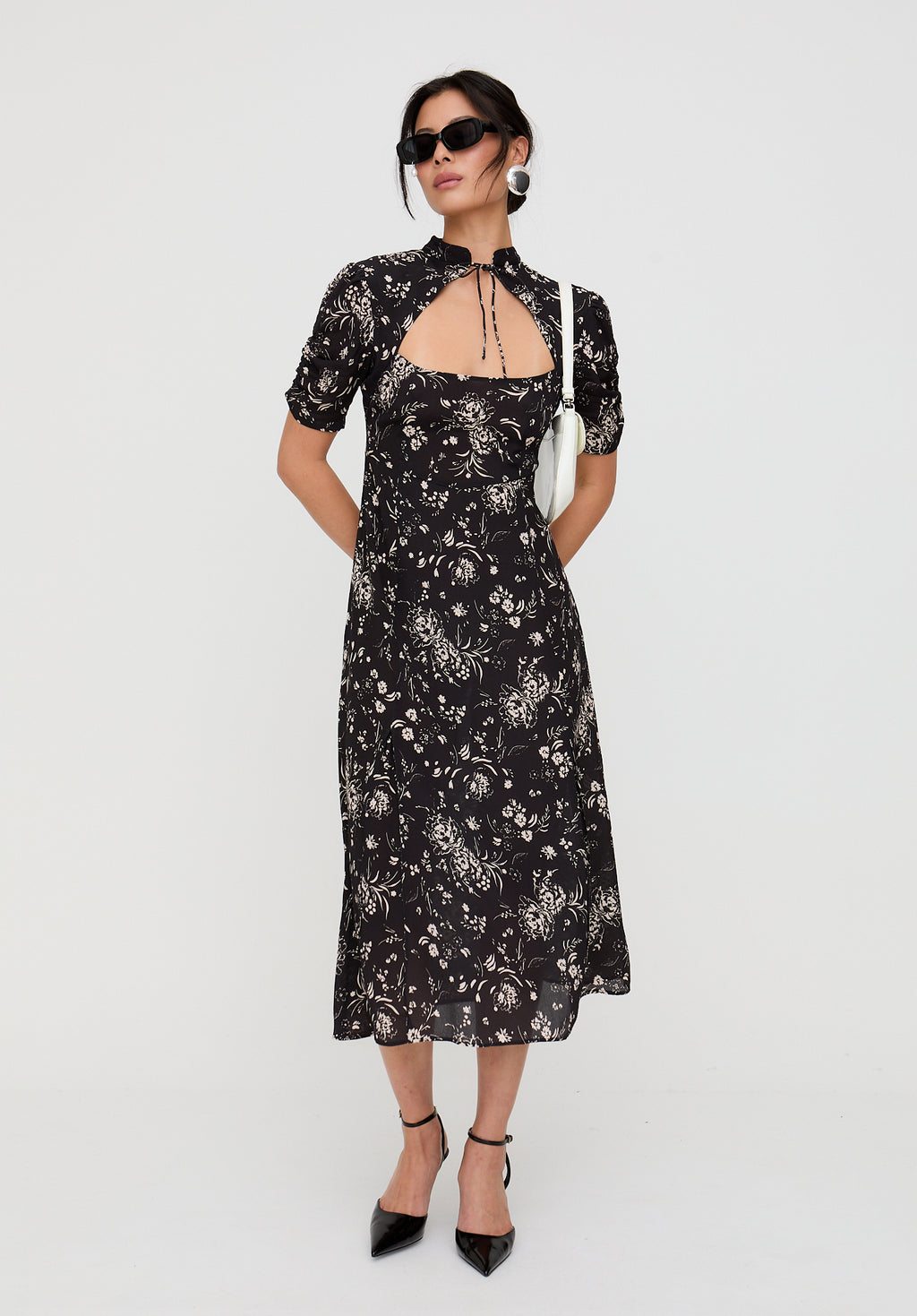 Woman wearing a black floral dress on a white background