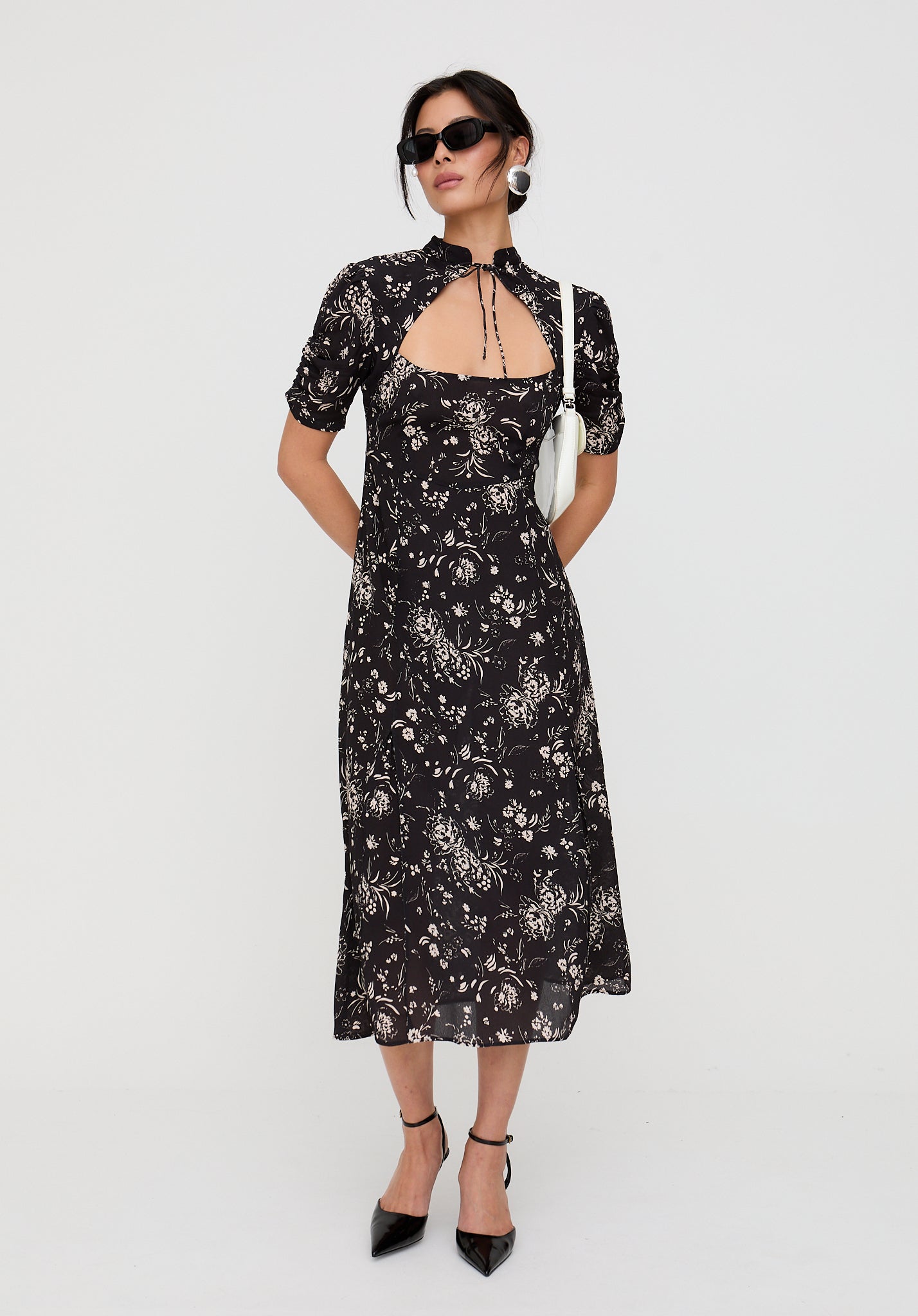 Woman wearing a black floral dress on a white background