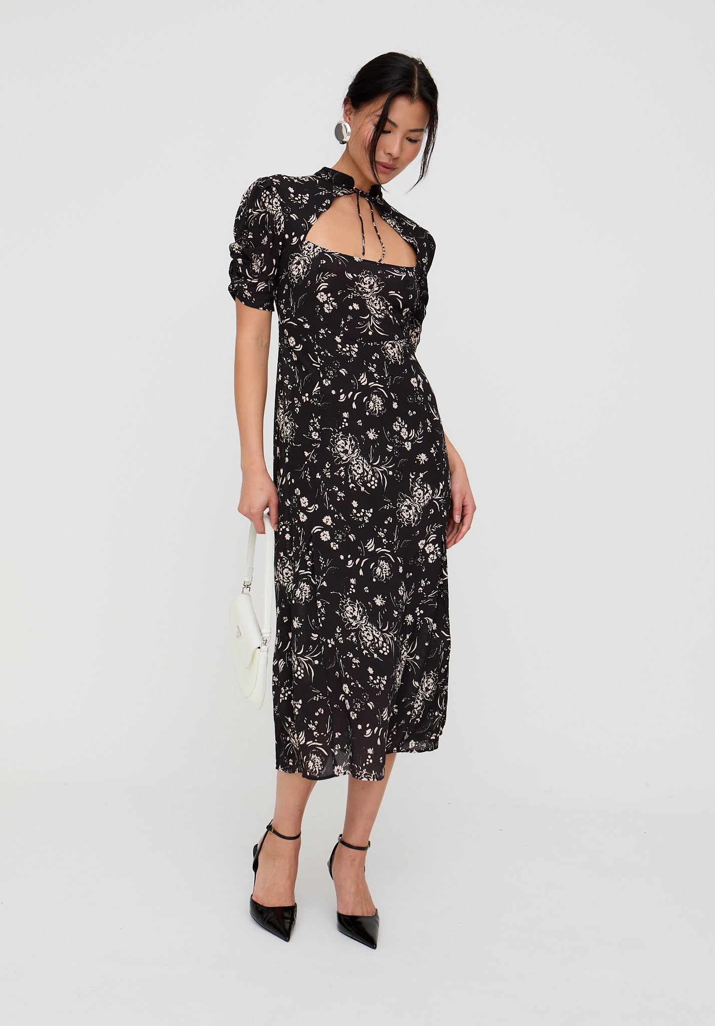 Woman wearing a black floral dress on a white background