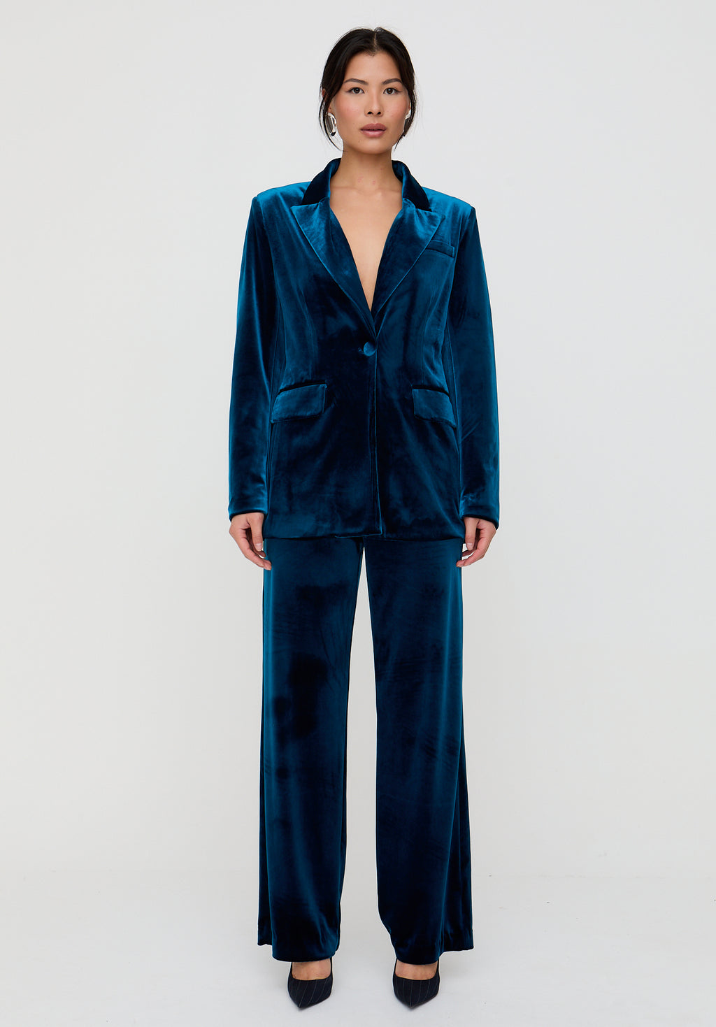 Woman wearing a blue velvet suit on a white background