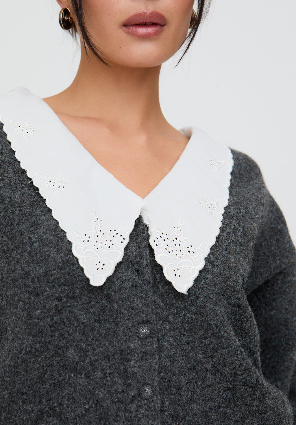 Gray sweater with white lace collar on a neutral background
