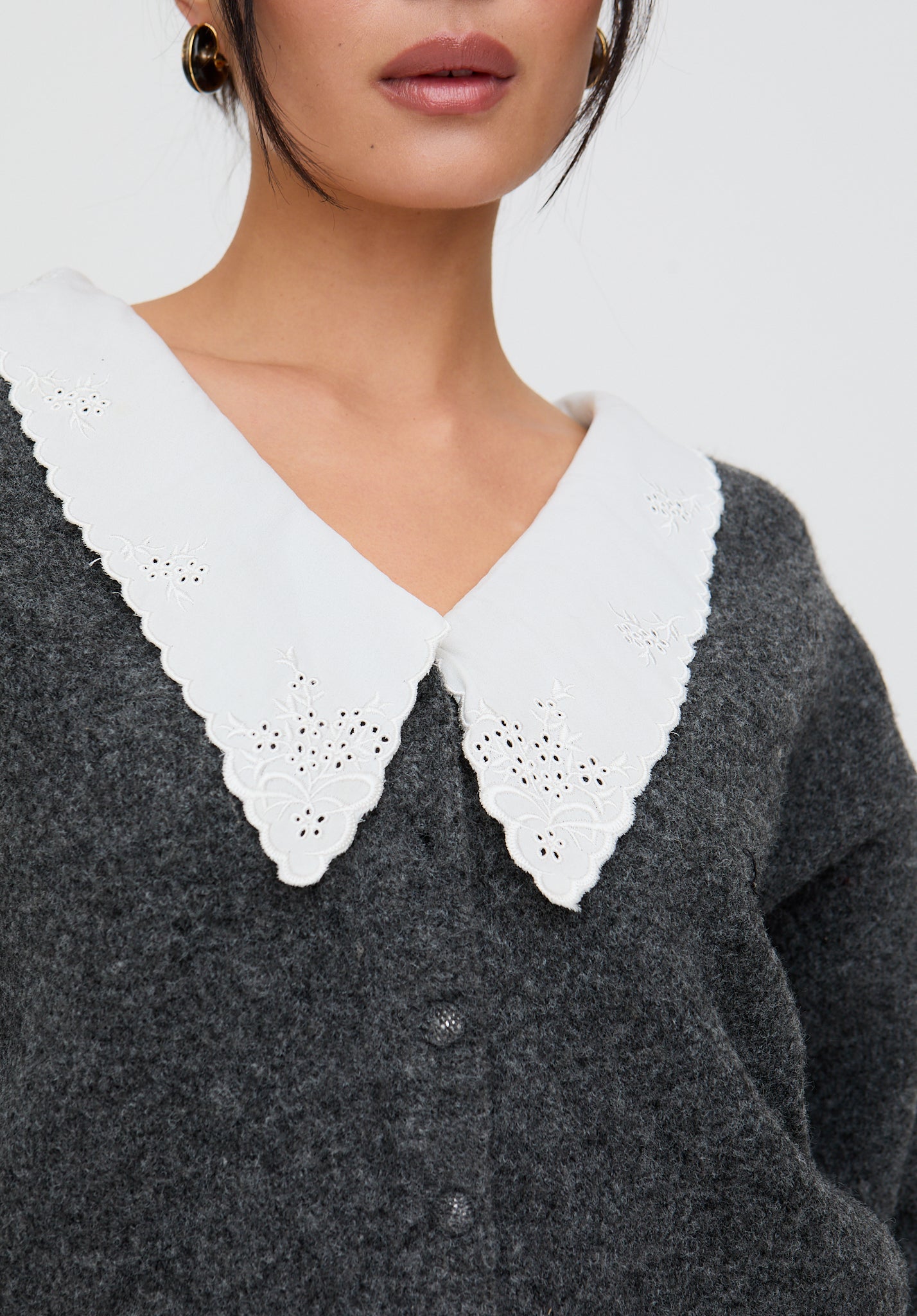 Gray sweater with white lace collar on a neutral background