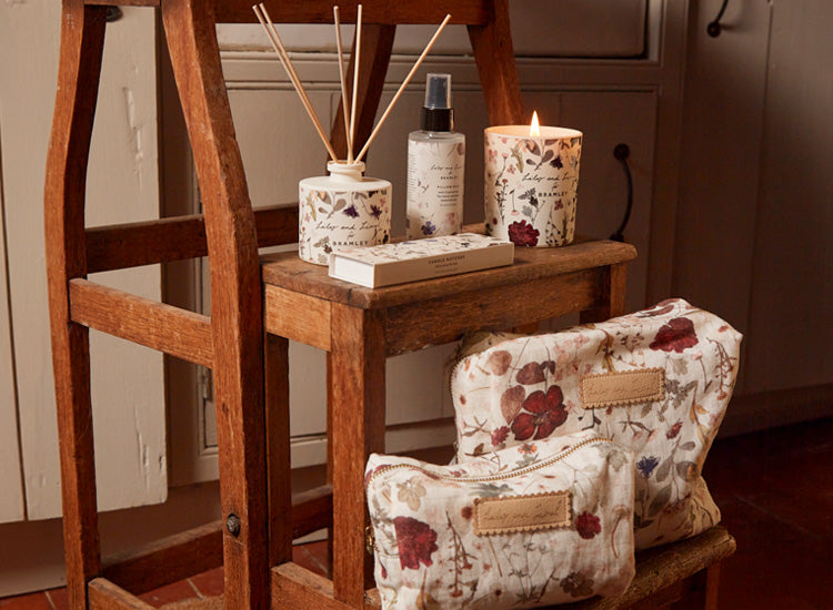 Collection of lifestyle products, including a candle, diffuser, pillow spray, wash bag and cosmetic bag in our cream pressed floral print. 