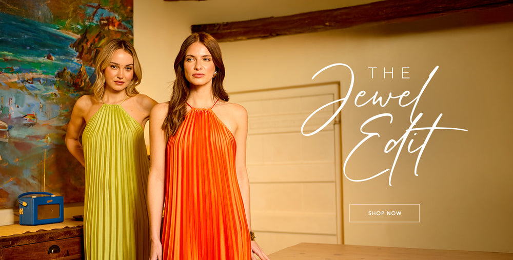 Models wear the Philomena Halter Neck Pleated Maxi Dress In Orange and matching Philomena Halter Neck Pleated Maxi Dress In Green. Copy on image 'The Jewel Edit - Shop Now'.
