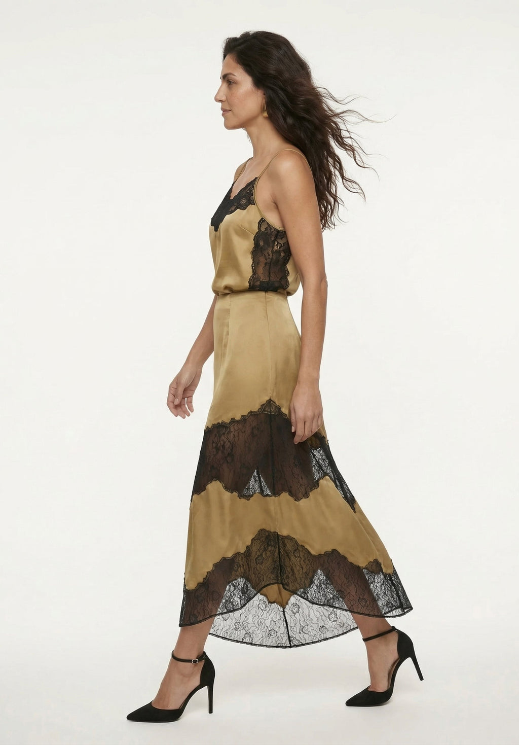 Woman wearing a beige dress with black lace details on a white background