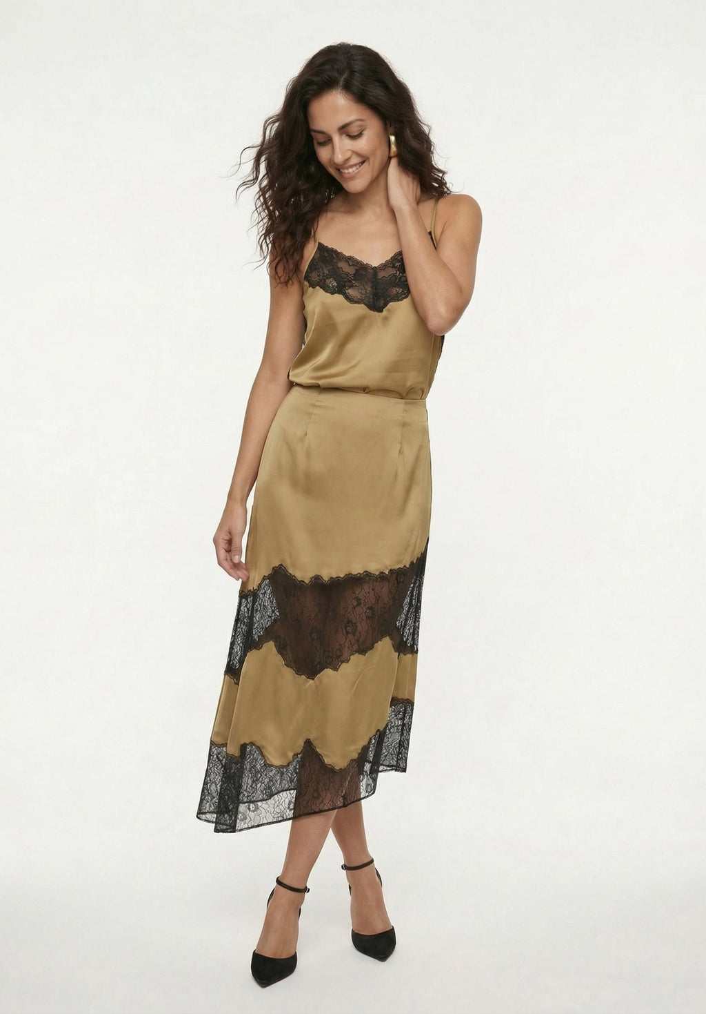 Woman wearing a beige dress with black lace details on a white background