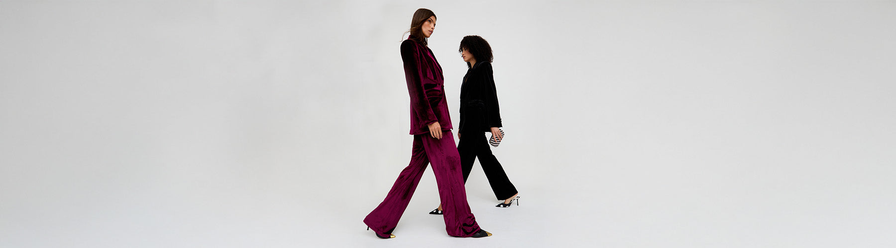 Two women walking side by side on a white background